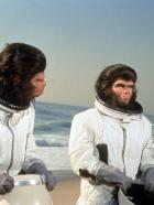 Flucht vom Planet der Affen - Dem intelligenten, der menschlichen Sprache mächtigen Schimpansenpaar Dr. Cornelius (Roddy McDowall, r.) und Dr. Zira und Dr. Milo (Sal Mineo, l.) gelingt mit einem notgelandeten US-Raumschiff die Flucht vom Planet der Affen. Sie begeben sich auf eine Zeitreise und landen schließlich in der Gegenwart an der Küste von Los Angeles ...
